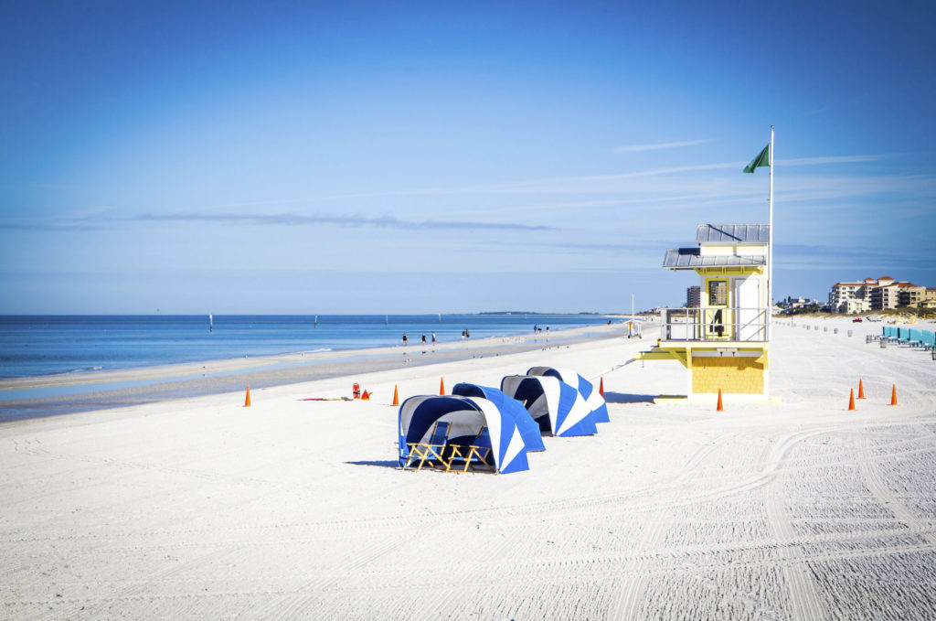 a beach with a lifeguard tower and a blue tarp