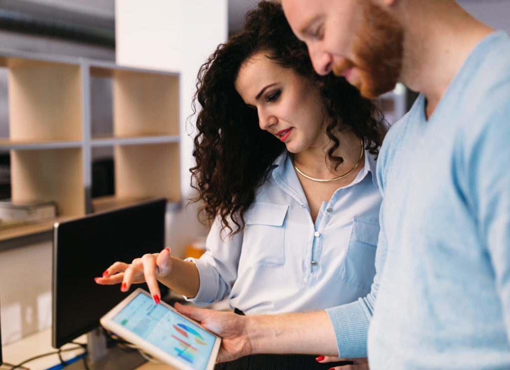 a man and a woman looking at a computer screen