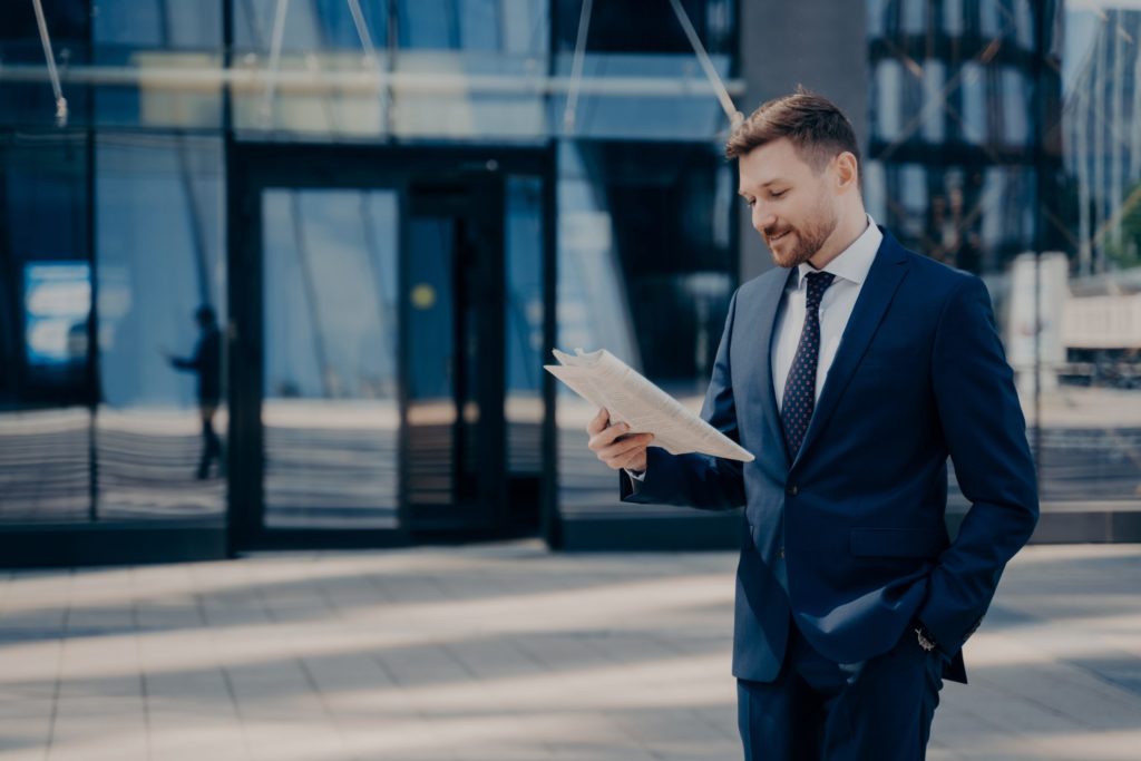 a man in a suit reading a newspaper